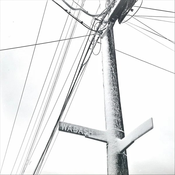 Pole and street sign covered with snow